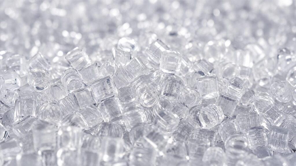 Close-up of transparent plastic resin pellets used as process-integrated materials optimized for injection molding manufacturing