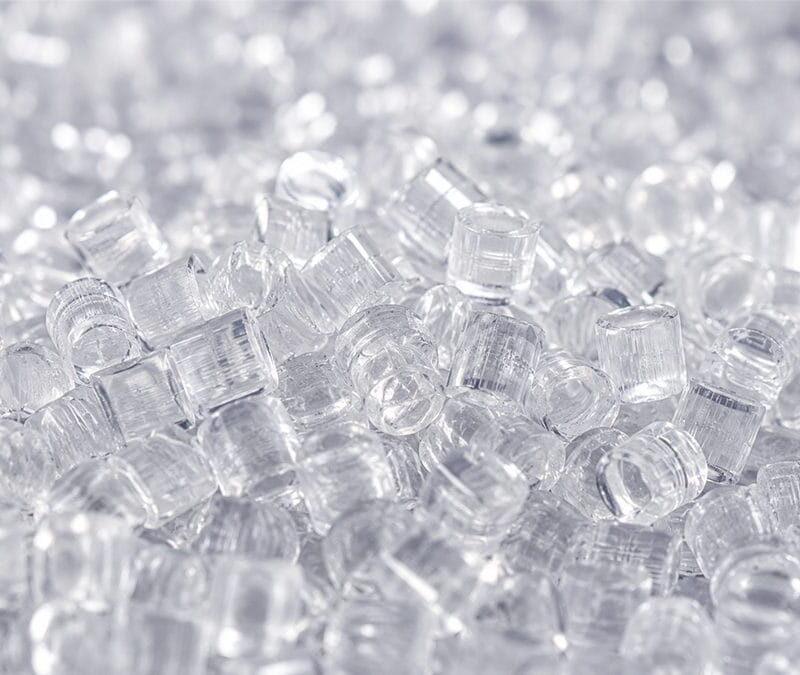 Close-up of transparent plastic resin pellets used as process-integrated materials optimized for injection molding manufacturing